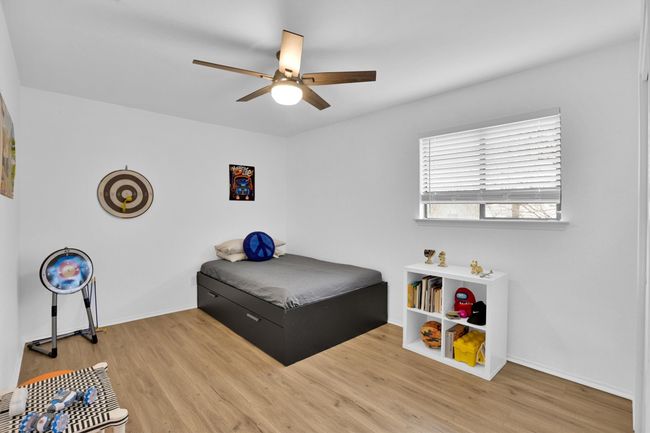 Bedroom with wood finished floors and ceiling fan | Image 25