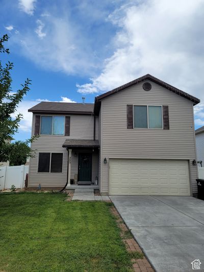 View of front of property with a front yard and a garage | Image 1