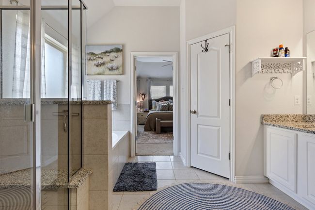 Ensuite bathroom featuring tile patterned flooring, vanity, ensuite bath, a garden tub, and a stall shower | Image 20