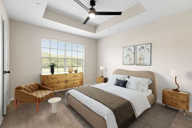 Bedroom with baseboards, a ceiling fan, a tray ceiling, and wood finished floors | Image 4