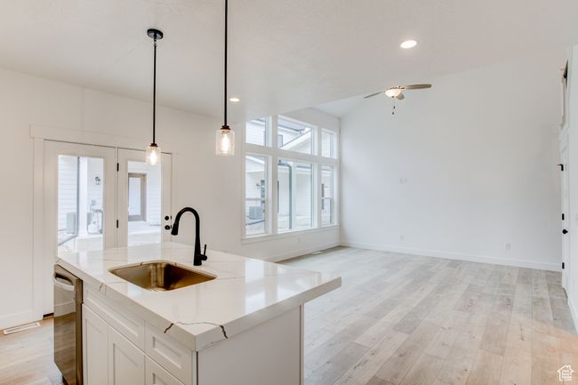 Kitchen featuring a sink, light wood finished floors, a ceiling fan, decorative light fixtures, and stainless steel dishwasher | Image 5