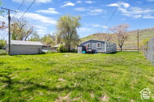 View of yard featuring fence and an outbuilding | Image 7