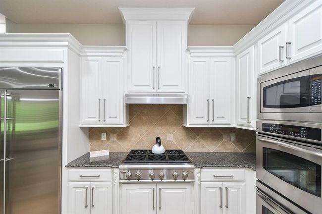 The chef's kitchen features marble countertops, professional-grade appliances, and a 6-burner gas range. | Image 18