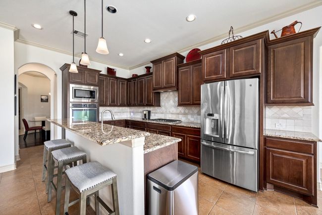 Another look at the kitchen that features a gas cook top and double ovens. | Image 15