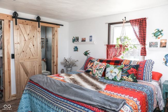 bedroom featuring a barn door and wood finished floors | Image 12