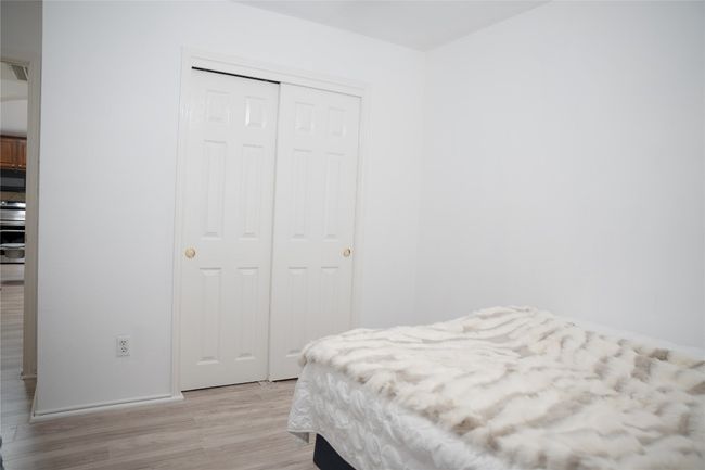 Bedroom with light wood-type flooring, a closet, and baseboards | Image 12