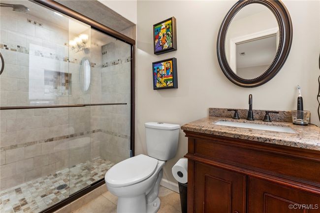 Bathroom with tile patterned floors, a stall shower, toilet, and vanity | Image 32