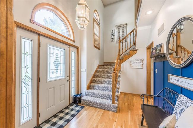 Foyer entrance featuring baseboards, stairs, visible vents, and wood finished floors | Image 18