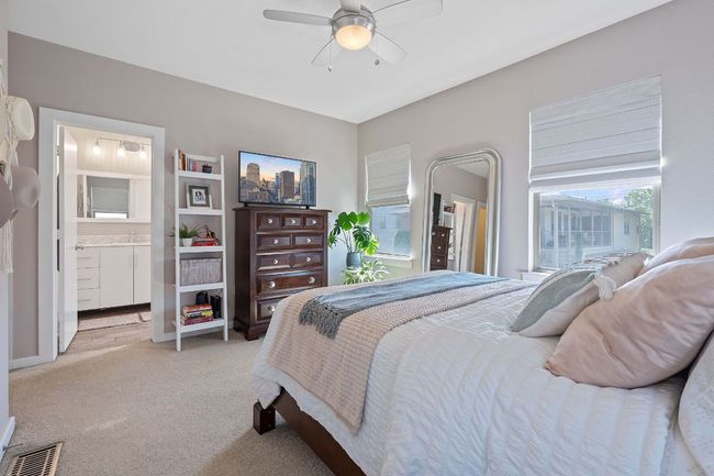 Bedroom featuring light carpet, ceiling fan, and ensuite bath | Image 14