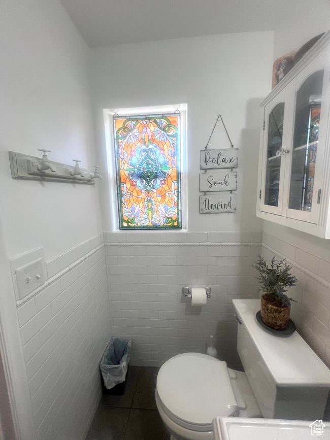 Bathroom with wainscoting, toilet, tile patterned flooring, and tile walls | Image 39