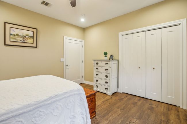 Bedroom with dark hardwood / wood-style floors, ceiling fan, and a closet | Image 21