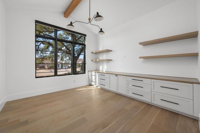 Bar with vaulted ceiling with beams, light wood-type flooring, baseboards, and pendant lighting | Image 23