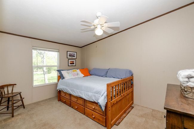 Bedroom featuring crown molding, a ceiling fan, and carpet | Image 13