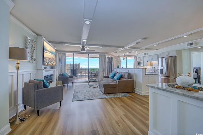 Living room featuring ornamental molding, sink, ceiling fan, and light hardwood / wood-style floors | Image 4