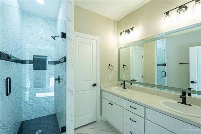 Bathroom featuring double vanity, marble finish floor, a sink, and a stall shower | Image 22