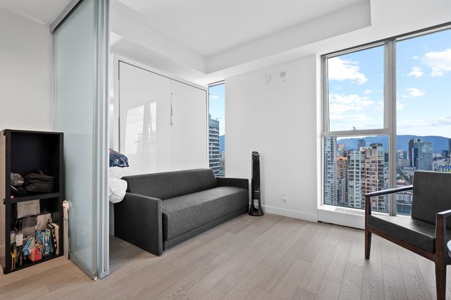 Sitting room with a view of city, light wood-style floors, and baseboards | Image 7