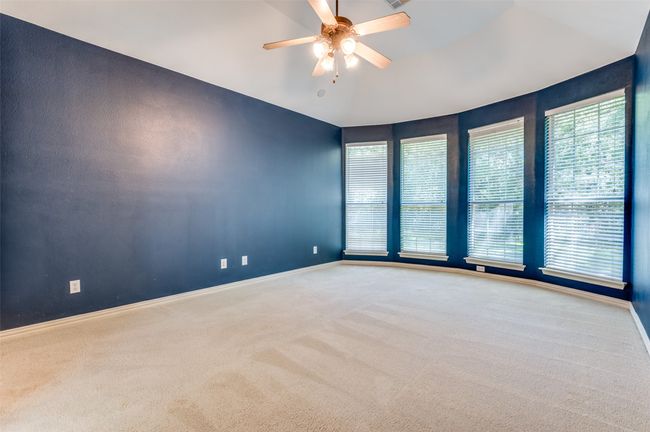 Primary bedroom with carpet flooring, a ceiling fan, and lofted ceiling | Image 12