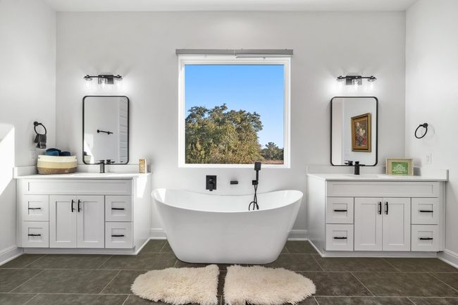 The primary ensuite luxury bath on the main level is a true retreat, offering a double vanity, walk-in closet, spa-like bath with a designer rain shower, and a freestanding tub. | Image 18