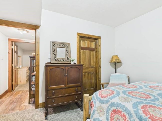 Bedroom 2 with light wood-type flooring and baseboards showing hallway to third bedroom and adjoining walk-in closet | Image 57