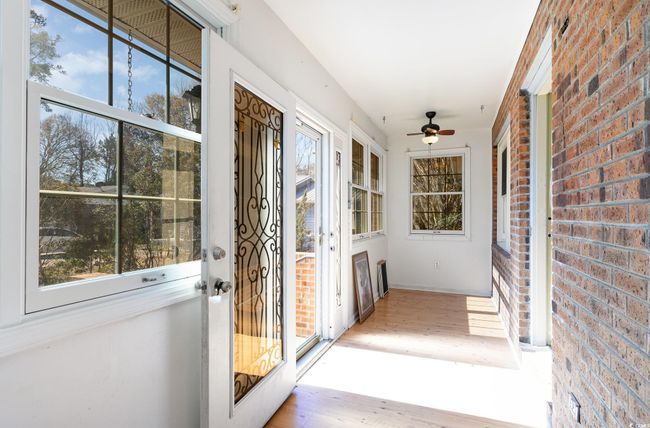 Doorway to outside featuring ceiling fan, brick wall, and light hardwood / wood-style floors | Image 23