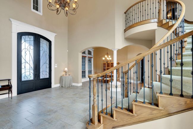 Foyer with a chandelier, arched walkways, a towering ceiling, french doors, and stairway | Image 9