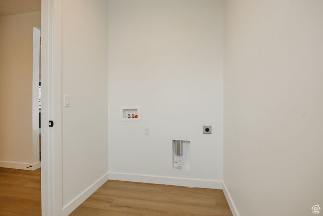 Laundry room with hookup for an electric dryer, washer hookup, light wood-type flooring, and baseboards | Image 25