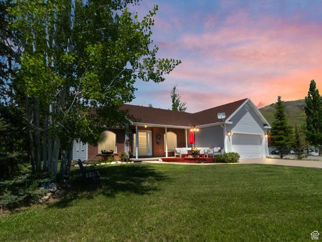 Ranch-style home with concrete driveway, an attached garage, a porch, a yard, and brick siding | Image 26