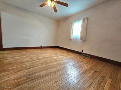 Empty room with light hardwood / wood-style floors and ceiling fan | Image 3