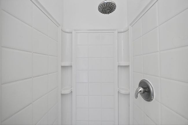 Bathroom view of tiled shower and tile walls | Image 28