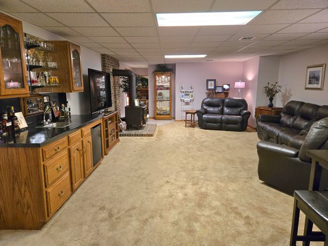The large family room has access to the game room. It also has a lovely wet bar and a wood stove | Image 19