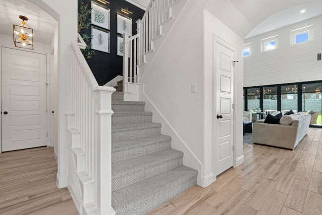Stairway featuring arched walkways, wood finished floors, baseboards, and a high ceiling | Image 26