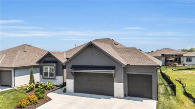 Ranch-style house with a front yard and a garage | Image 2