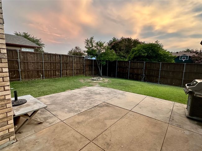 Patio terrace at dusk with a fenced backyard, a patio area, and a grill | Image 37