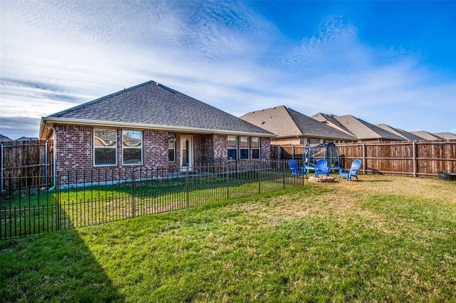 Back of property featuring a trampoline and a yard | Image 23