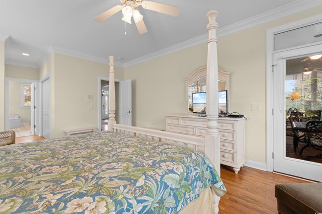 Bedroom featuring crown molding, light wood-type flooring, ensuite bathroom, and a ceiling fan | Image 15