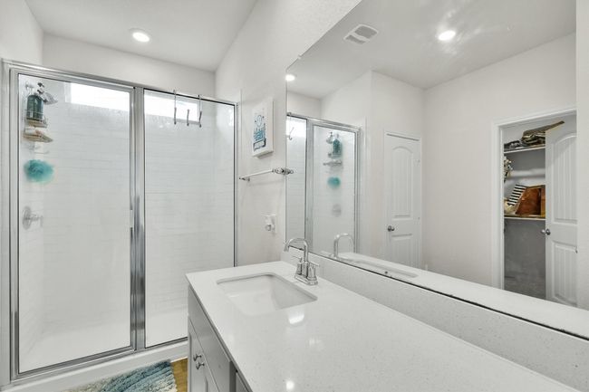 Bathroom with a stall shower, vanity, recessed lighting, and a walk in closet | Image 19