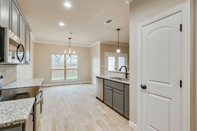 Kitchen featuring stainless steel appliances, a sink, gray cabinetry, a chandelier, and tasteful backsplash | Image 6