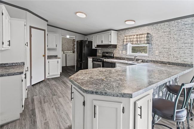 a peninsula breakfast bar area and pantry | Image 10