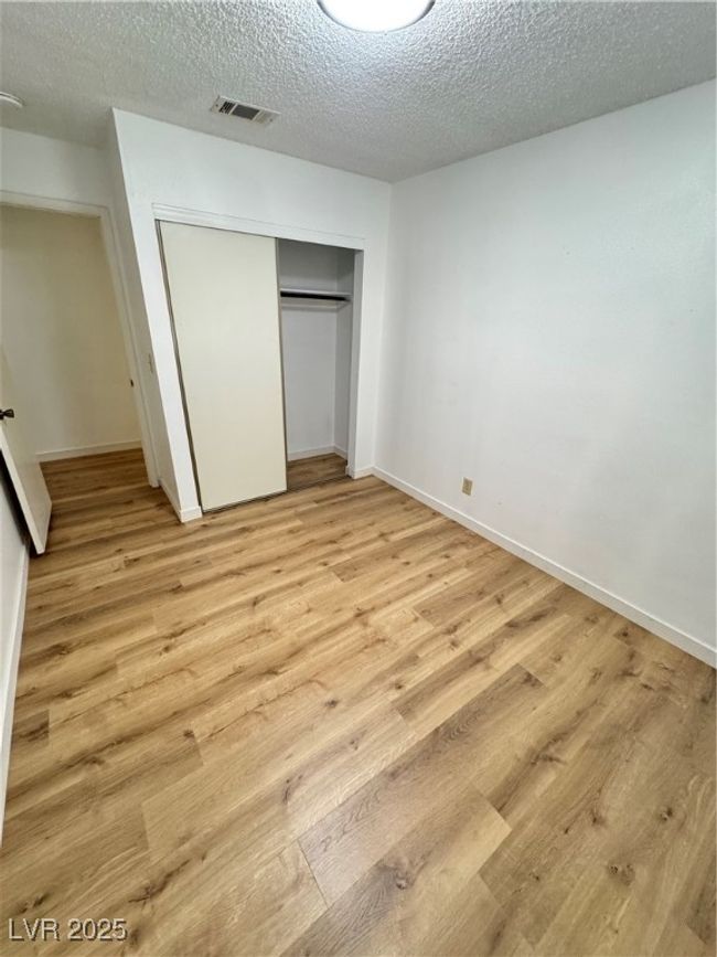 Unfurnished bedroom featuring a closet, light wood-type flooring, and a textured ceiling | Image 36