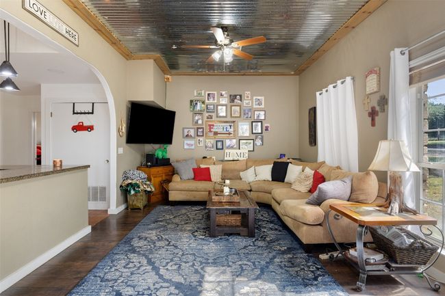 Living area featuring ceiling fan, dark wood-style flooring, arched walkways, and baseboards | Image 16