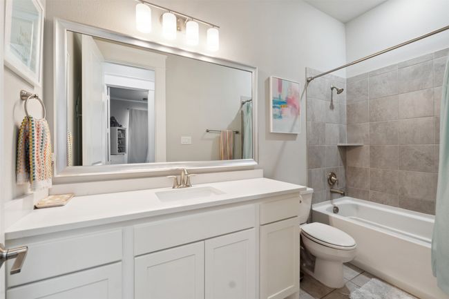 Full bathroom with vanity, shower / bathtub combination with curtain, and tile patterned flooring | Image 5
