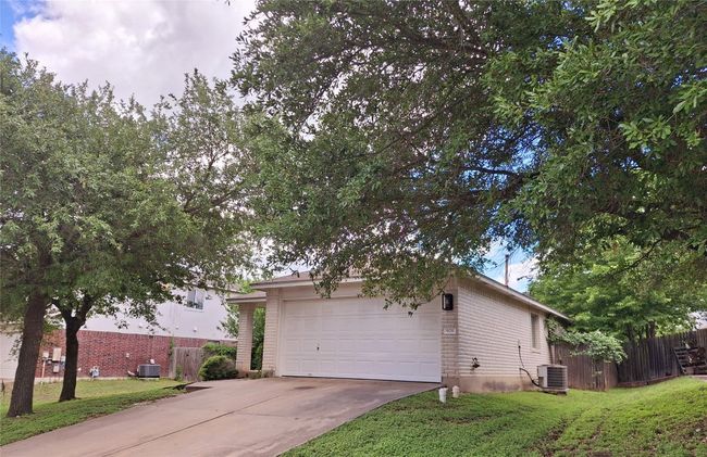 Obstructed view of property with driveway, central air condition unit, and a garage | Image 27