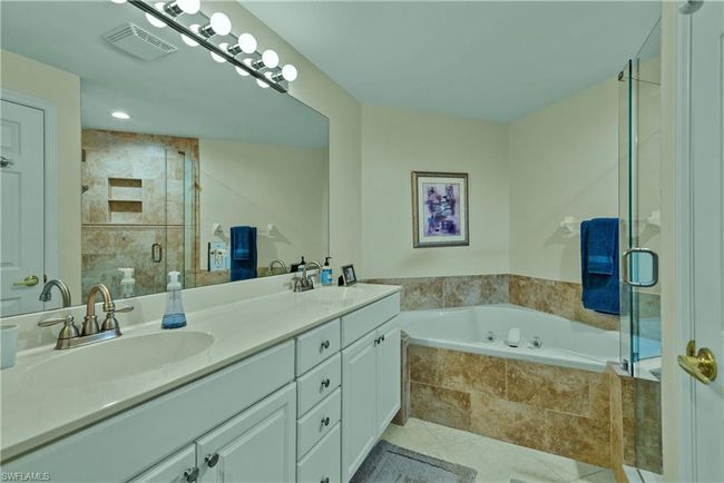 Bathroom featuring tile patterned floors, vanity, and shower with separate bathtub | Image 13