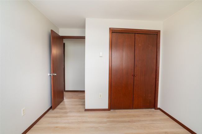 Unfurnished bedroom with light wood finished floors, a closet, and baseboards | Image 16