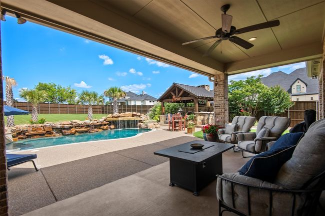 Fenced backyard with an outdoor hangout area, a gazebo, a patio, and a ceiling fan | Image 34