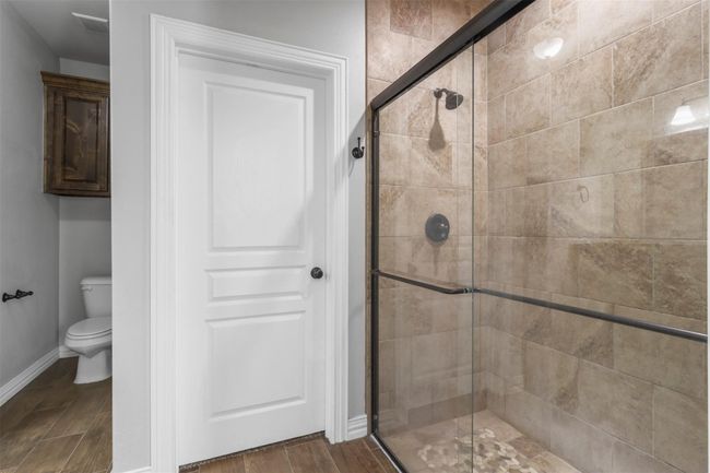 Bathroom featuring a stall shower and wood finished floors | Image 11