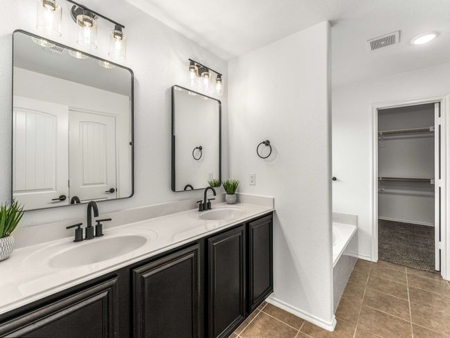 Full bath with double vanity, tile patterned flooring, a bathtub, and a walk in closet | Image 20