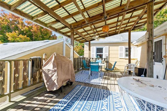 Wooden deck featuring a ceiling fan and outdoor dining space | Image 5