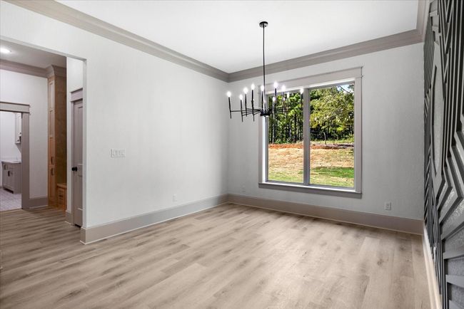 Unfurnished dining area with ornamental molding, light wood finished floors, and a chandelier | Image 10