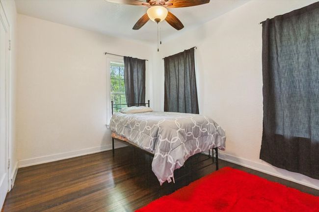 Bedroom with baseboards, ceiling fan, and wood finished floors | Image 25